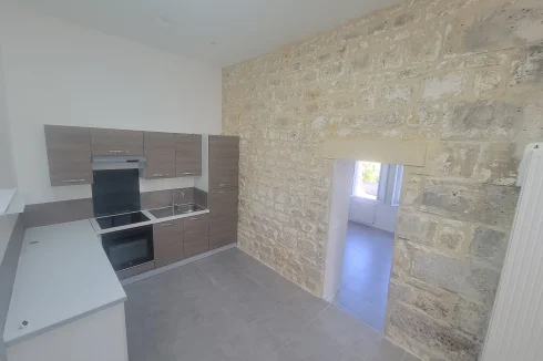 Open kitchen with exposed stone wall and dining area