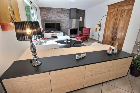 Open plan living area with feature wall & stove