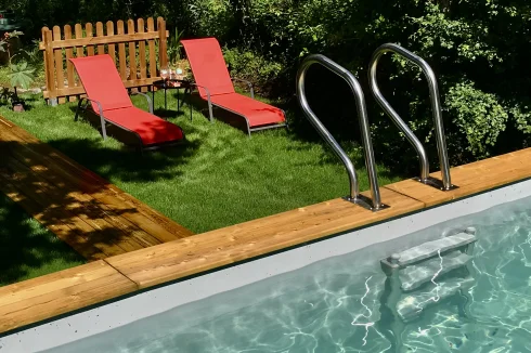 The pool area with red lounge chairs