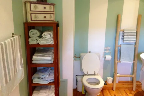 Petite salle de bain. Lavabo et baignoire à droite.