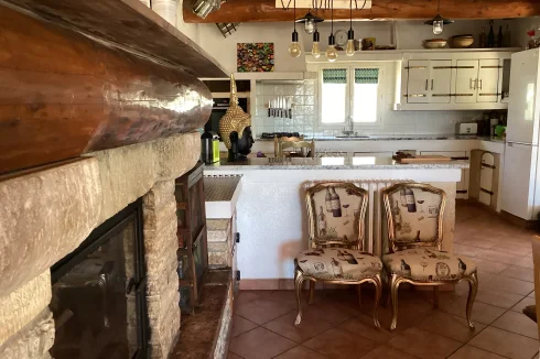 Renovated open concept kitchen and dining area with a wood burning fireplace