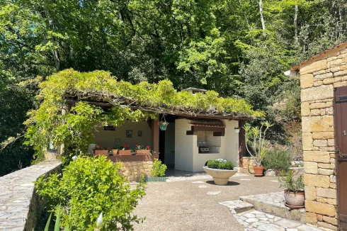 The summer kitchen is adorned with purple flowering wisteria from April to June, adding a touch of beauty and charm.