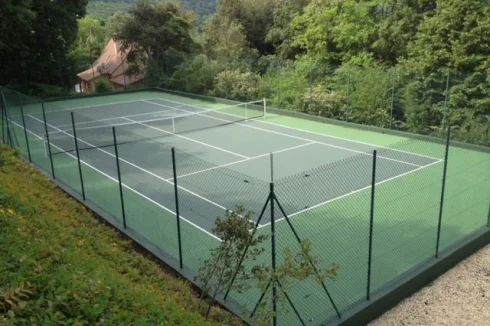 The tennis court features new foundations and a fresh acrylic surface, ensuring durability and an excellent playing surface.