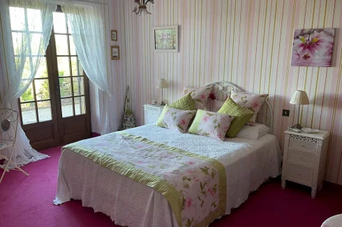 The pink bedroom provides a charming and spacious setting with delightful views and cozy ambience.