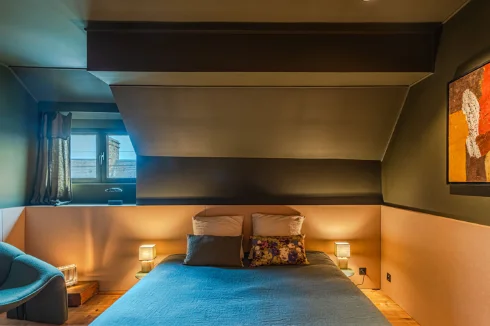 Intimate and warm atmosphere, with subdued lighting and a large wardrobe built into an entire wall.